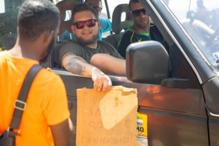A Hungarian participant holding a ‘for sale’ card for his vehicle