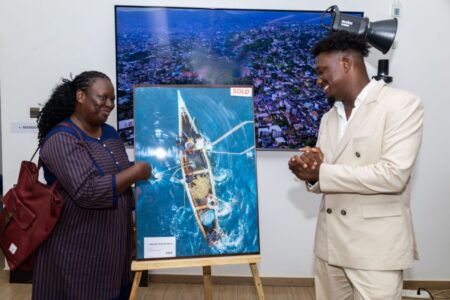 Sama Kai and a buyer of one of his images at his exhibition