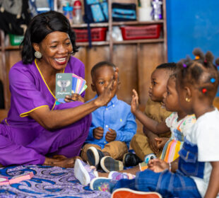 A learning coach uses Yak Jones Foundation African - inspired alphabet flash cards and Sierra Leone landmark puzzles