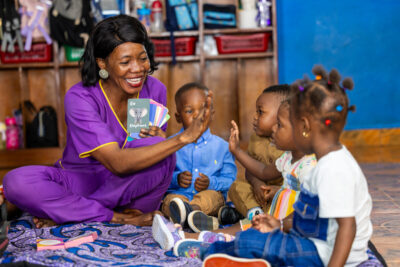 A learning coach uses Yak Jones Foundation African - inspired alphabet flash cards and Sierra Leone landmark puzzles