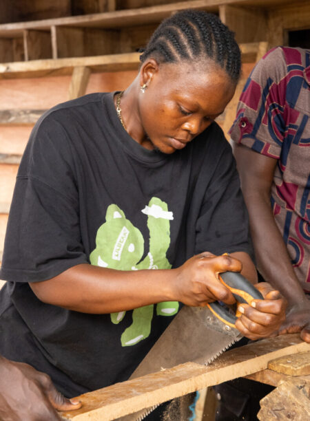Jariatu Sannoh is sawing a board