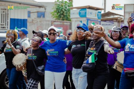 Minister of Tourism and Cultural Affairs Hon. Nabeela Farida Tunis (middle) and staff celebrating in a street parole during the Launch of Year of Ecotourism 2025