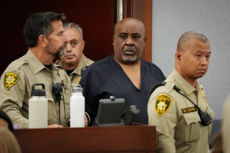 Showing the killer with security entering the court